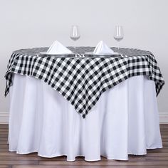 the table is set with two wine glasses and a black and white checkered tablecloth