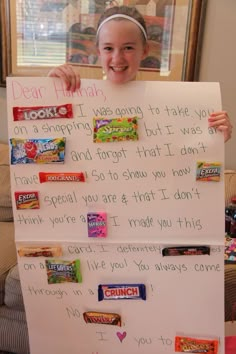 a child holding up a sign with candy on it