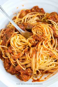 a white bowl filled with spaghetti and meat sauce