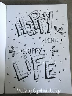 an open book with the words happy mind and life written on it in black ink