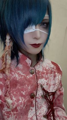 a doll with blue hair and eye makeup