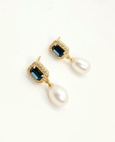 Soft white fresh water pearl oval drop with emerald rectangle cut Montana navy blue or emerald green crystal centered gold plated post earrings with cubic deco. Size: 2.5cm x .8cm Average Pearl size 8mmx10mm (+ - 1mm) Due to the nature of natural pearl, shape, color and size may vary from picture shown. . Returns and exchange details   Customer Satisfaction Guarantee: Below policy will replace standard ETSY policy- please read carefully before purchasing. If you are not satisfied with an item fo Exquisite Pearl Drop Jewelry, Elegant Rectangular Pearl Drop Earrings, Elegant Oblong Gemstone Jewelry, Exquisite Oval Pearl Drop Jewelry, Blue Pearl Charm Drop Earrings, Elegant Blue Pearl Earrings, Elegant Silver Oblong Jewelry, Dainty Rectangular Jewelry For Formal Occasions, Elegant Emerald Cut Earrings