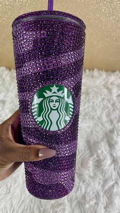 a hand holding up a purple starbucks cup covered in swaro - studded crystals