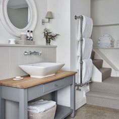 a bathroom sink sitting under a mirror next to a wooden counter