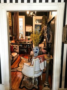 a living room with black and white striped walls, wood flooring, and furniture