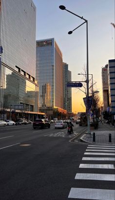 a city street with tall buildings in the background