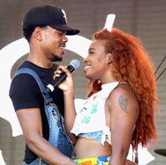 a man and woman standing next to each other on stage with a microphone in their hand