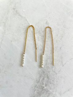 "Super dainty threader earrings with teeny tiny white or peach rice seed pearls hanging from gold filled chain or sterling silver chain. Seed pearls are tiny, 2mm-3mm size.  Earring is 3.5\" tip to tip. So lightweight you can barely feel them. Sold as a pair."