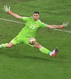 a man kicking a soccer ball on top of a field