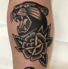 a black and white tattoo with a tiger on it's leg, surrounded by flowers