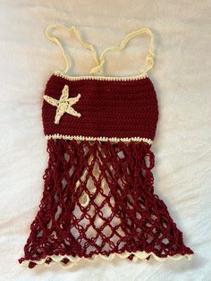 a crocheted red and white bathing suit with starfish on the front, attached to a string