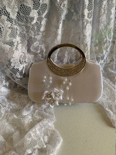 "Beautiful fall bag, amazing details, handmade satin flowers with pearls and crystals. Dimensions: 8\"long x 6.5\" high x 2\" deep NO RETURNS, NO EXCHANGE, PLEASE CONTACT FOR ANY ADDITIONAL QUESTIONS." Beige Pearl Embellished Evening Bag For Wedding, Rectangular Satin Wedding Bag, Beige Pearl Evening Bag For Wedding, Cream Pearl Evening Bag For Wedding, White Pearl-embellished Bag For Wedding Guest, White Pearl Embellished Evening Bag For Wedding Guest, Elegant Evening Bridal Accessories With Pearl Handle, Elegant Bridal Accessories With Pearl Handle For Evening, Silver Pearl Wedding Bag