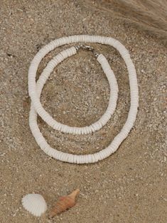 "This choker necklace features quality white shell heishi beads. The literal meaning of heishi (pronounced hee-shee) is \"shell\" and these beads are made using pieces of oyster shell (also known as mother-of-pearl) made into flat beads. A string of good heishi will have a uniform consistency in bead size and if you gently pull it through your hand, it should feel like a single serpent-like piece. When you look closely at each bead, you see the amazing detail and unique coloration of each bead. Pula Shell Necklace, White Heishi Beads Jewelry For Vacation, White Shell Necklace With Round Beads For The Beach, White Round Beads Shell Necklace For Beach, Summer White Heishi Beads Necklaces, Adjustable Single Strand Shell Necklace For Beach, White Heishi Beads Single Strand Jewelry, White Heishi Beads Necklace For Beach, White Jewelry With Letter Beads For Vacation