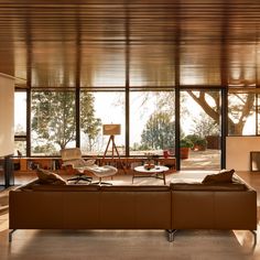 a living room with large windows and leather furniture