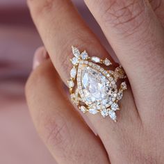 a woman's hand with a diamond ring on top of her finger and an engagement band