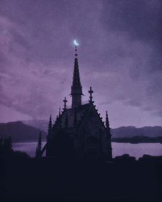 an old church tower with a moon in the sky above it and water behind it