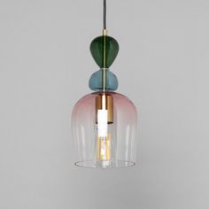 a pink and blue glass light hanging from a ceiling