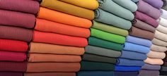 many colors of clothing are stacked on top of each other in the same color scheme