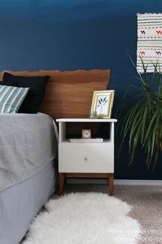 a bedroom with blue walls and white furnishing