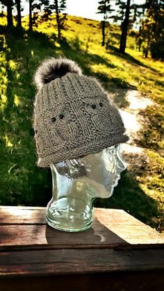 a knitted hat sitting on top of a glass head