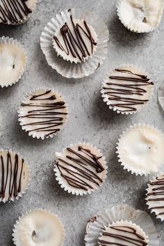 chocolate covered cupcakes with white frosting and drizzled on top