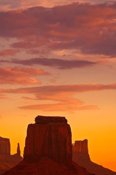 the sun is setting over monument rock in arizona