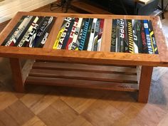 a wooden table with books on it in front of a couch and coffee table made out of skis