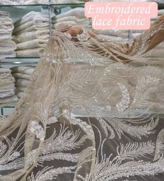 an embroidered lace fabric is on display in a store