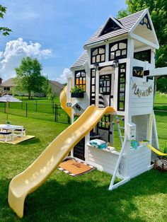 a play house with a slide in the grass