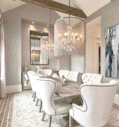 an elegant dining room with chandelier and white chairs