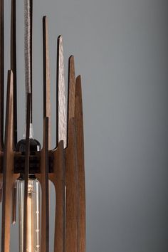 a light that is hanging from the ceiling with some wood pieces on top of it