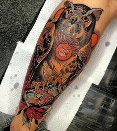 an owl tattoo on the arm and leg is shown in black and grey colors with orange accents