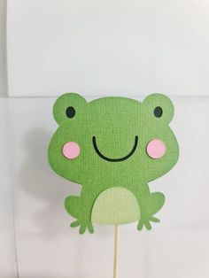 a cake topper with a green frog on it