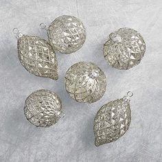 five silver ornaments sitting on top of a table