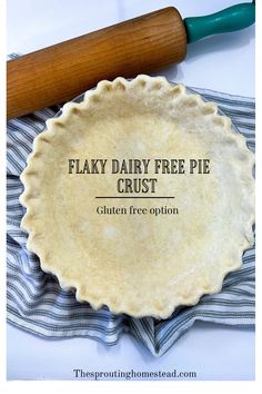 a pie crust sitting on top of a blue towel next to a rolling pin with the words, flaky dairy free pie crust written in it