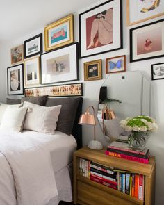 a bedroom with pictures on the wall above the bed