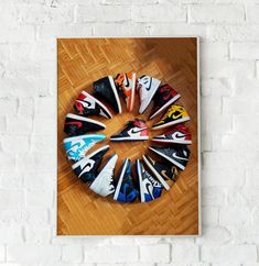 there are many shoes on the floor in front of a white brick wall with a wooden frame