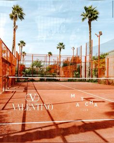 an empty tennis court with palm trees and the words valentio in white on it