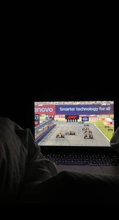 a person sitting in front of a laptop computer on top of a bed next to a pillow