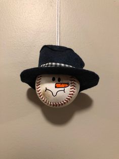 a baseball ornament with a hat on top of it hanging from a wall