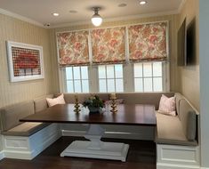 a corner table with benches in front of two windows