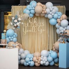 a blue and white balloon arch with the words oh, places you'll go written on it