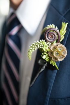 a man wearing a suit and tie with a boutonniere on his lapel