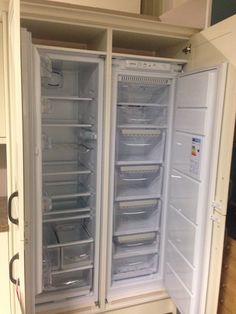 two open refrigerators sitting side by side in a kitchen