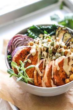 a bowl filled with meat, vegetables and dressing