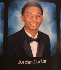 a man in a tuxedo and bow tie is smiling at the camera with his name on it