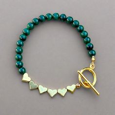 Malachite and Gold Heart Toggle Bracelet - T. Randall Jewelry Green Heart Beads Bracelet Jewelry, Green Heart Beads Bracelet, Gold Malachite Bracelet, Adjustable Green Heart Beads Jewelry, Adjustable Green Jewelry With Heart Beads, Green Jewelry With Heart Charm And Round Beads, Adjustable Green Jewelry With Heart Charm, Metal Hearts, Bracelet Elegant