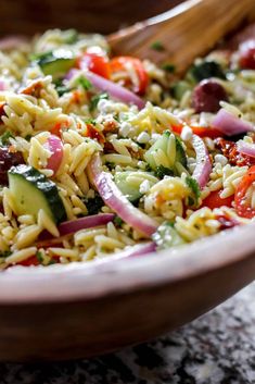 a close up of a bowl of food with rice and veggies in it