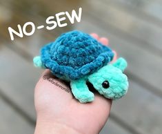 a hand holding a small crocheted turtle with the words no sew on it