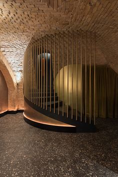 a spiral staircase in the middle of a room with curtains on either side and a round light at the end